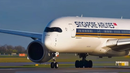 Singapore Airlines wide-body aircraft on the tarmac with landing gear extended and a clear blue sky overhead