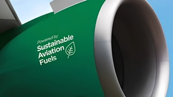 Green aircraft fuselage with Sustainable Aviation Fuels branding and a leaf motif next to a silver turbofan
